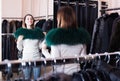 Woman trying on fur neckpiece in womenÃ¢â¬â¢s cloths store